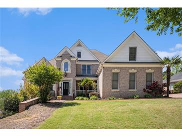 Beautiful brick home with manicured lawn and mature trees on a sunny day at 1950 Lancaster Se Dr, Conyers, GA 30013