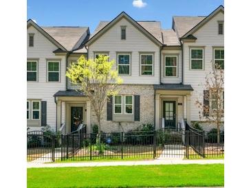 Charming townhome with well-maintained lawn, neutral siding, and a wrought iron fence at 309 Vista Ln, Woodstock, GA 30189