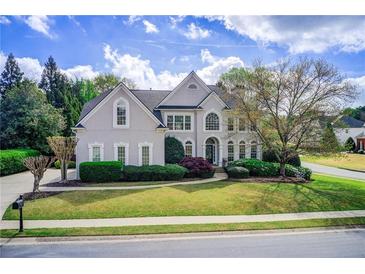 Beautiful two-story home with manicured lawn, mature landscaping, and a charming front porch at 1900 Denton Walk Ct, Marietta, GA 30062