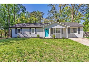 Charming single-story home with a well-manicured lawn and a bright blue front door at 8304 Ephesus Church Rd, Villa Rica, GA 30180