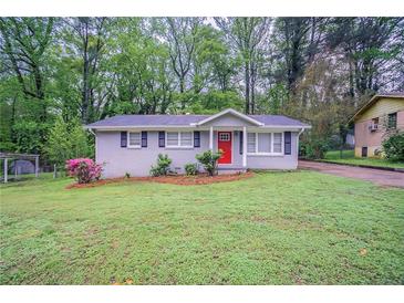 Charming single-story home with a well-maintained lawn and a vibrant red front door at 2038 Thomasville Se Dr, Atlanta, GA 30315