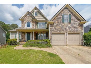 Charming two-story stone home featuring a well-manicured lawn and a two-car garage at 31 Vine Creek Ln, Acworth, GA 30101