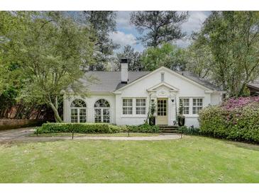 Charming white brick home with manicured lawn and lush landscaping, showcasing classic curb appeal at 703 Cumberland Ne Cir, Atlanta, GA 30306