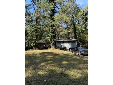 View of the exterior of the home with large front yard at 865 Cherrydale Ln, Woodstock, GA 30189