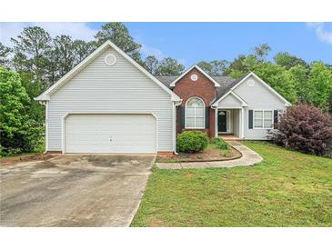 Charming single Gathering home featuring vinyl siding, brick accents, and a well manicured lawn at 206 Towler Dr, Loganville, GA 30052