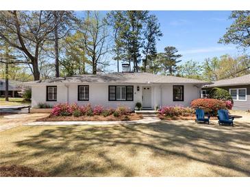 Charming white brick home with manicured lawn and blue Adirondack chairs on the front lawn at 200 Heaton Park Dr, Decatur, GA 30030