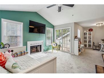 Cozy living room features a fireplace, high ceilings, and sliding glass door at 2016 River Heights Se Walk, Marietta, GA 30067