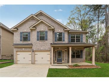 Charming two-story home with a two-car garage and a welcoming front porch at 3892 Trillium Wood Trl, Snellville, GA 30039