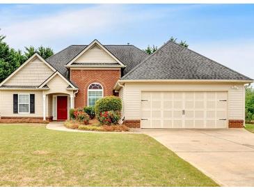 Charming single-Gathering home with brick and vinyl siding, complemented by a well-manicured lawn and mature landscaping at 57 Craig Meadows Ln, Douglasville, GA 30134
