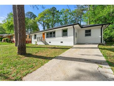 Charming single-story home features a bright orange front door and long concrete driveway at 2146 Trailwood Rd, Decatur, GA 30032