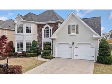 Charming two-story home with a two-car garage, landscaped front yard, and a combination of stucco and stone facade at 5241 Marston Rd, Atlanta, GA 30360