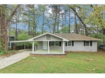 Charming single-story home with a covered front porch and well-maintained lawn surrounded by mature trees at 3711 Daisy Dr, Decatur, GA 30032
