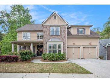 Charming two-story home with a well-manicured lawn, a two-car garage, and a covered front porch at 3907 Fellowship Dr, Buford, GA 30519