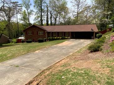 Charming brick home with an expansive driveway and well-maintained front yard landscaping at 4141 Fredericksburg Dr, College Park, GA 30337