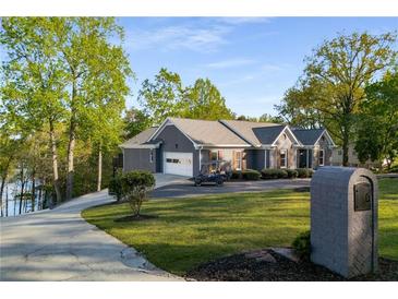 Lovely single-story home boasting a lush lawn, spacious driveway, and attached garage near the waterfront at 6477 Old Shadburn Ferry Rd, Buford, GA 30518