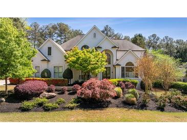 Beautiful white house featuring professionally landscaped yard and a symmetrical facade at 1010 Lake Shore Overlook, Alpharetta, GA 30005