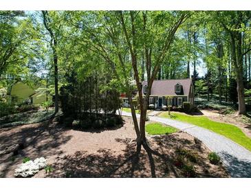 Charming one-story home with lush landscaping and a winding gravel driveway at 1745 Shady Hill Ne Rd, Marietta, GA 30068