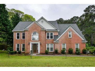 Traditional two-story brick home featuring well-manicured lawn, classic architectural detailing, and a welcoming front entrance at 2238 Roseberry Ln, Grayson, GA 30017