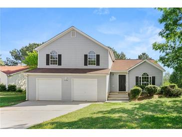 Charming two-story home featuring a two-car garage and well-manicured front lawn at 7194 Oakwood Cir, Rex, GA 30273
