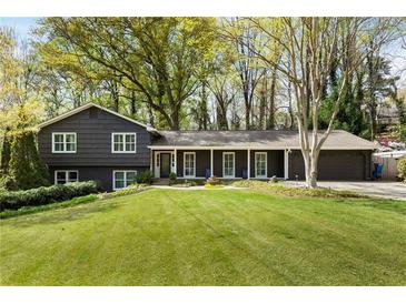 Charming home featuring a well-manicured lawn, gray siding and symmetrically placed windows at 259 Dartmoor Cir, Atlanta, GA 30328