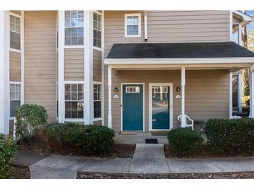 Inviting townhome featuring dual front doors with covered entryway and manicured landscaping at 6390 Magnolia Ln, Morrow, GA 30260