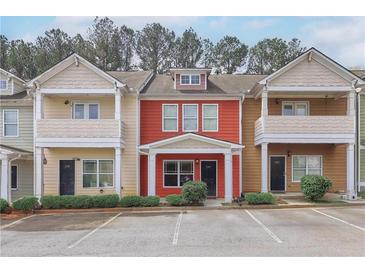 Charming townhouse featuring a red exterior, well-maintained landscaping, and convenient parking at 1797 Brookside Lay Cir, Norcross, GA 30093
