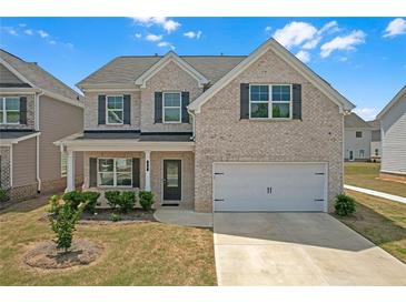 Charming two-story home with a light brick exterior, attached garage, and beautifully manicured landscaping at 70 Clark Lake Ln, Grayson, GA 30017