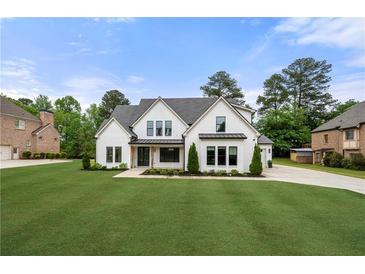 Inviting two-story home with a well-manicured lawn and charming curb appeal on a sunny day at 1375 Harris Rd, Lawrenceville, GA 30043