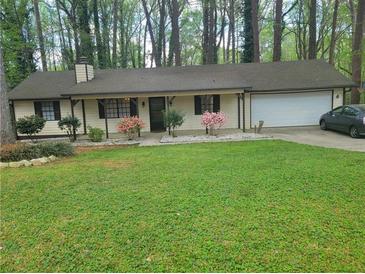 Charming one-story home with a well-maintained yard and flowering bushes along the front at 4148 Silver Hill Ct, Snellville, GA 30039
