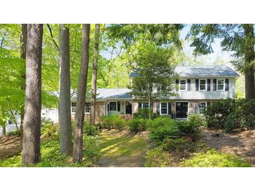 Charming two-story home with a well-manicured lawn and mature trees creating a serene, wooded setting at 2940 Blue Sky Pl, Marietta, GA 30068