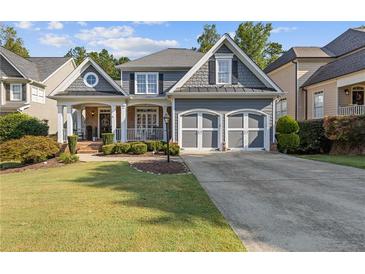 Charming two-story home featuring a well-manicured lawn, inviting porch, and a two-car garage at 5724 Kendrick Ln, Cumming, GA 30041