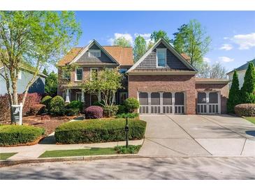 Beautiful brick home with a three car garage, mature landscaping, and manicured lawn at 4620 Westgate Dr, Cumming, GA 30040