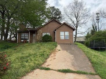 Charming single-story home with a stone chimney and driveway at 4817 Mainstreet Valley Trce, Stone Mountain, GA 30088