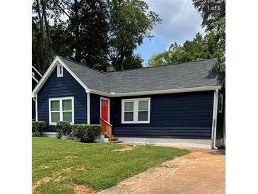 Charming home with a dark blue exterior, red door, and well-manicured lawn at 609 Spring St, Atlanta, GA 30354
