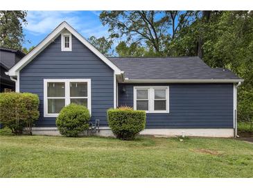 Charming blue home featuring manicured landscaping and bright white trim, adding to its curb appeal at 609 Spring St, Atlanta, GA 30354
