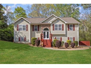 Charming two-story home with a well-manicured lawn and a welcoming front entrance with stone accents and red shutters at 6332 Fairoaks Pl, Douglasville, GA 30135
