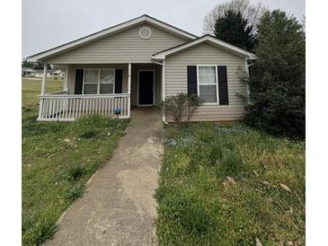 Charming single-story home with a welcoming front porch and well-maintained lawn and an inviting walkway at 118 Dove Lndg, Social Circle, GA 30025