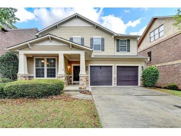 Inviting two-story home with a covered front porch and a two-car garage at 13030 Dartmore Ave, Alpharetta, GA 30005