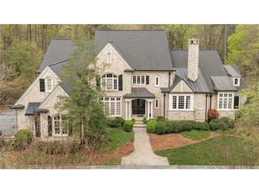 Stunning stone home boasts lush landscaping and a welcoming front entrance with a classic design at 440 Old Homestead Trl, Johns Creek, GA 30097