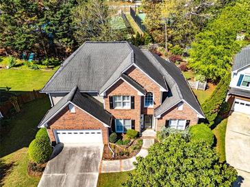 Stunning brick home featuring a two-car garage and lush landscaping, perfect for curb appeal at 1630 Chadwick Mill Ln, Lawrenceville, GA 30043