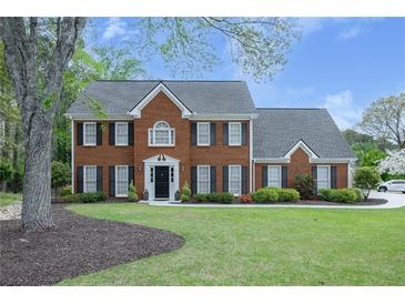 Charming two-story brick home with black shutters and a well-manicured front yard, perfect for curb appeal at 4950 Willow Creek Dr, Woodstock, GA 30188