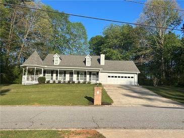 Charming single-story home featuring a welcoming front porch and a two-car garage, set on a lush green lawn at 105 Whisper Way, Dacula, GA 30019