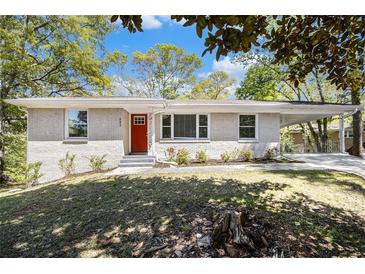 Charming single-story home with a white brick exterior and a vibrant red front door at 293 Howell Sw Dr, Atlanta, GA 30331