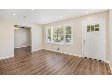 Bright living room featuring a large window, hardwood floors, and fresh, neutral paint at 293 Howell Sw Dr, Atlanta, GA 30331