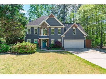 Charming two-story home featuring a stone accent wall, two-car garage, and a lush, green lawn at 3578 Hope Rd, Cumming, GA 30041