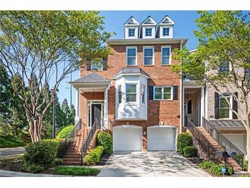 Beautiful brick townhouse with two-car garage, well-manicured landscaping and welcoming front entrance at 5888 Riverstone Cir # 15, Atlanta, GA 30339