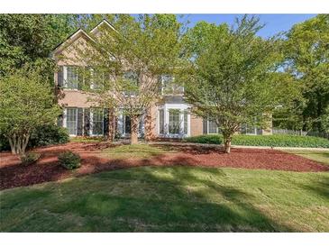 Charming two-story brick home with well-manicured front yard and mature trees at 6221 Woodlore Nw Dr, Acworth, GA 30101
