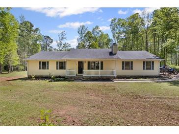 Charming single-story home featuring a covered porch and large front yard on a sunny day at 175 Springvalley Way, Stockbridge, GA 30281