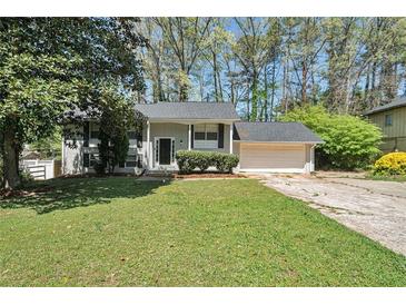 Charming split-level home with a well-manicured lawn, attached garage, and beautiful landscaping at 4590 Cedar Ridge Trl, Stone Mountain, GA 30083
