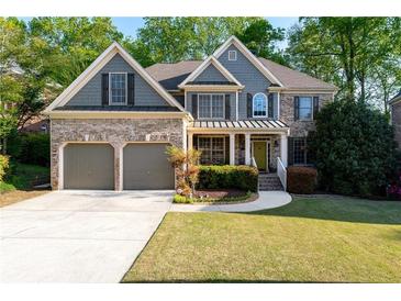 Charming two-story home with manicured lawn, brick accents, and a two-car garage at 1207 Promontory Path, Marietta, GA 30062